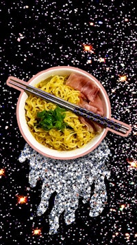 a plate of noodles with chopsticks on it