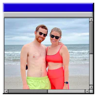 a man and woman posing for a photo on the beach